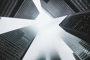 Misty city scene with towering skyscrapers disappearing into the fog, creating a moody urban environment.