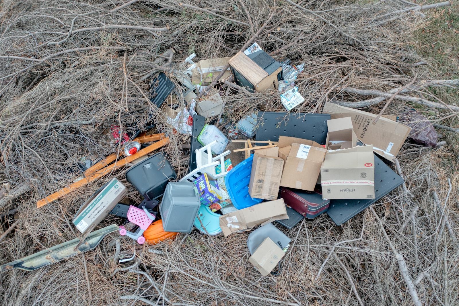 Aerial view of mixed trash and debris scattered in a dry, natural environment.