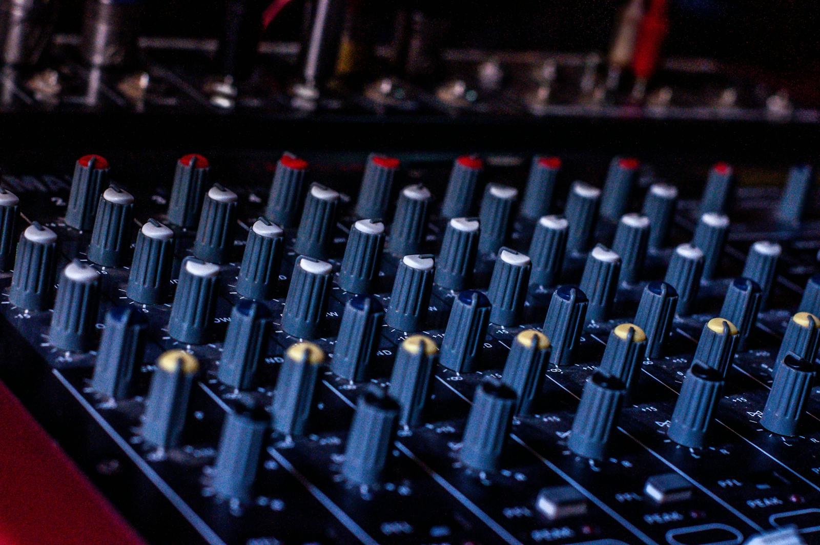 Detailed shot of audio mixer controls in a studio setting, showcasing precision technology.