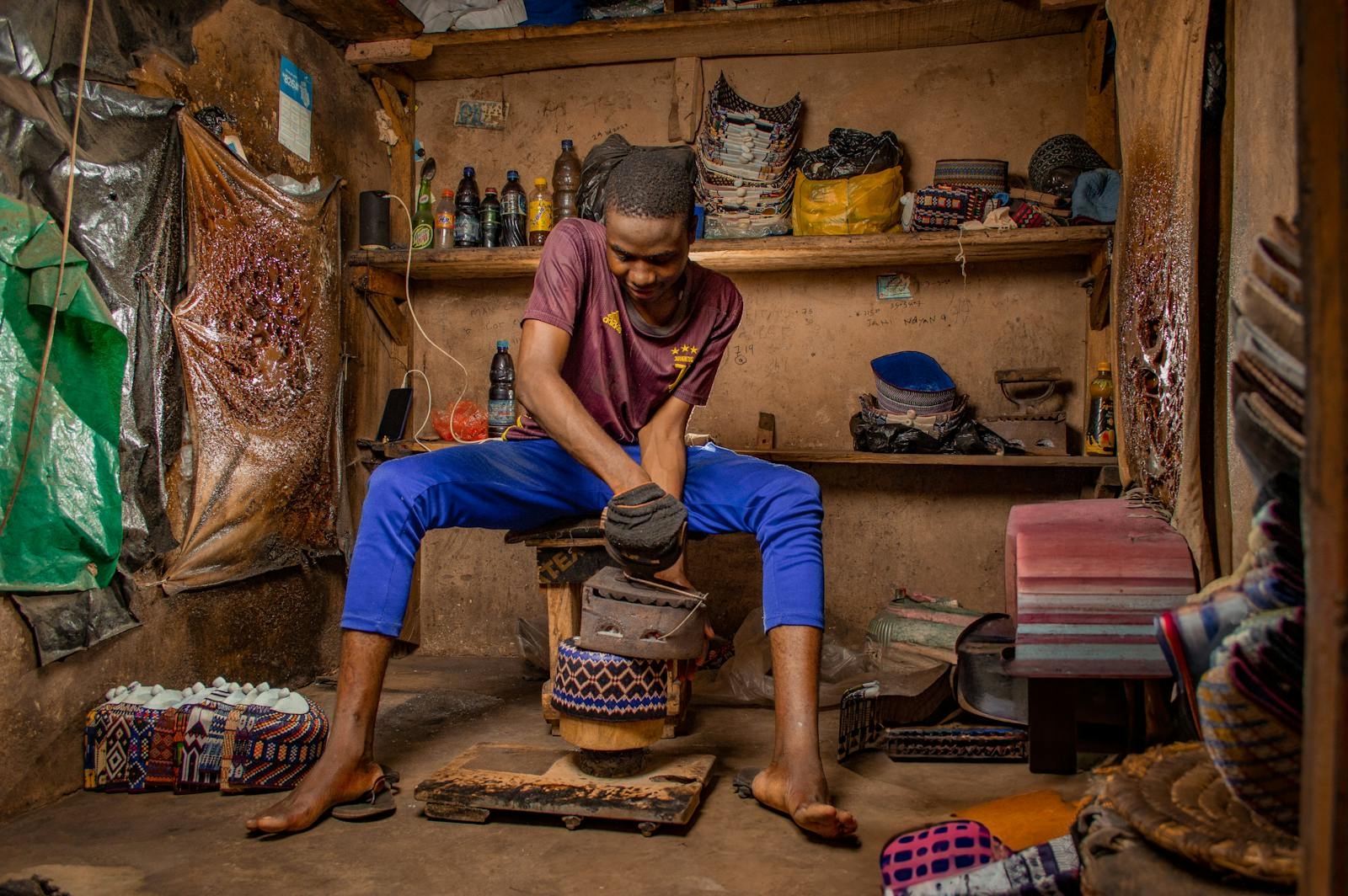 Nigerian artisan skillfully crafting shoes in a traditional workshop in Kano, Nigeria.