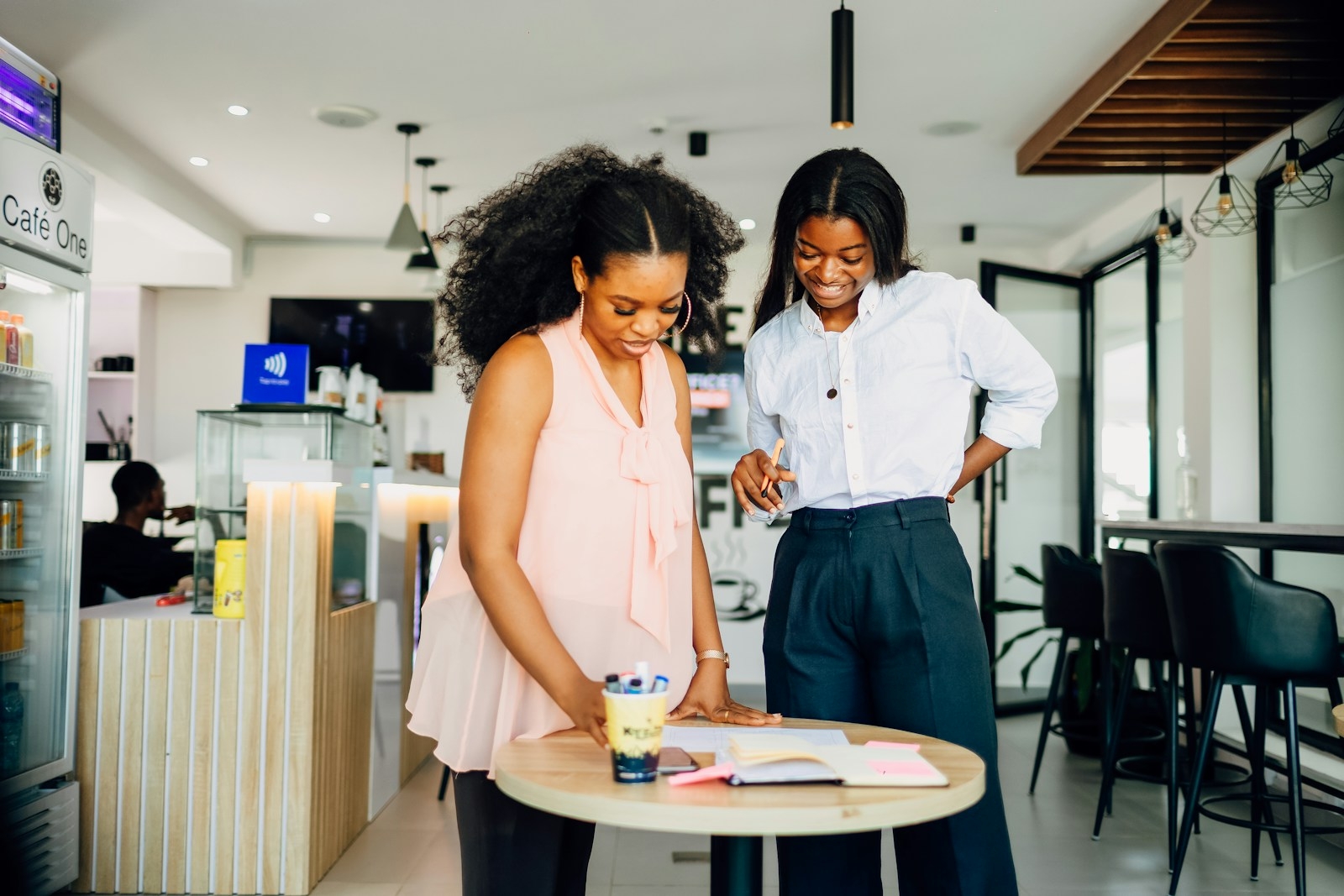 A couple of women standing next to a table