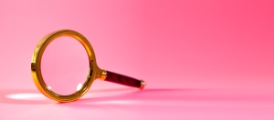 A magnifying glass on a pink background