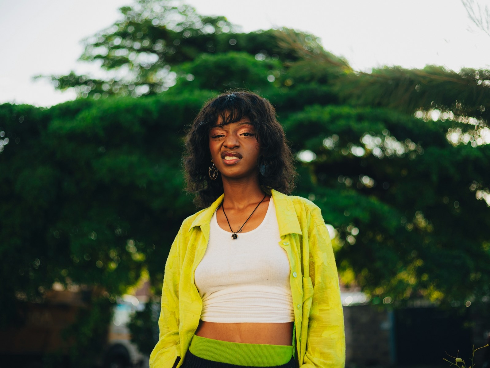 Young woman in a lime green jacket outdoors.